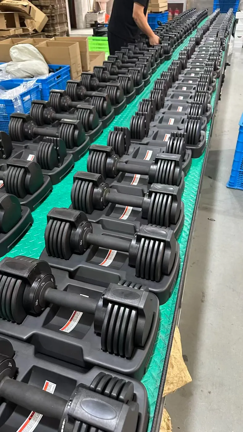 Black adjustable dumbbells on production line